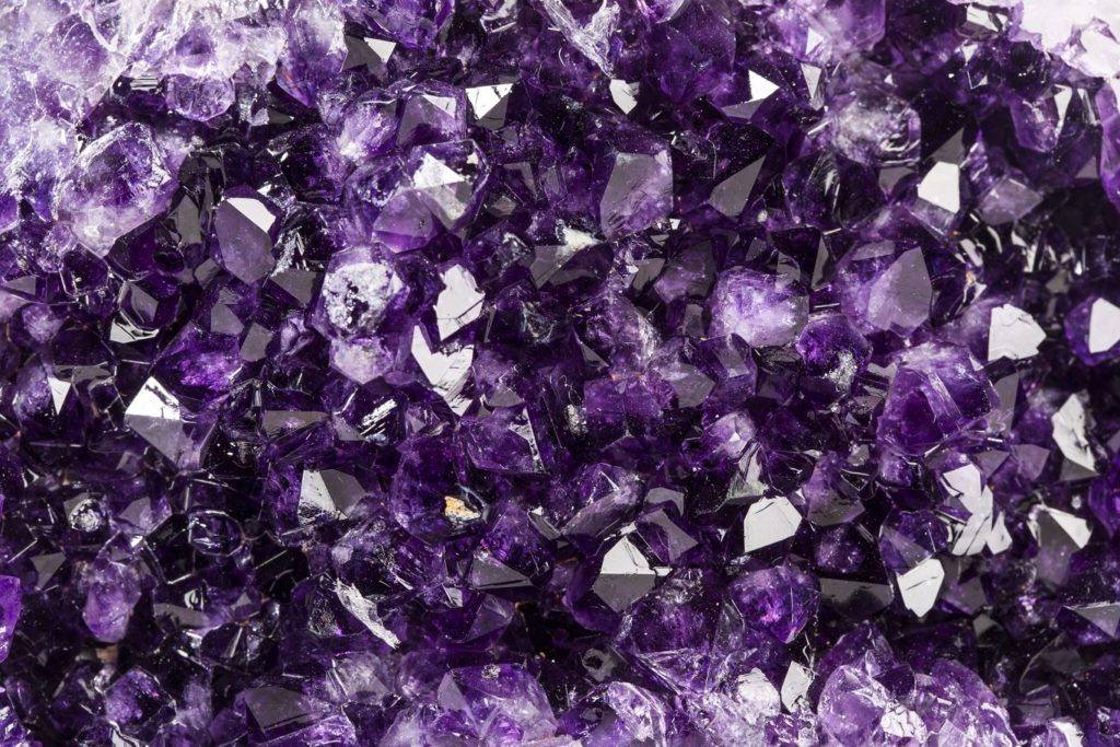 A dense cluster of dark purple amethyst stones.