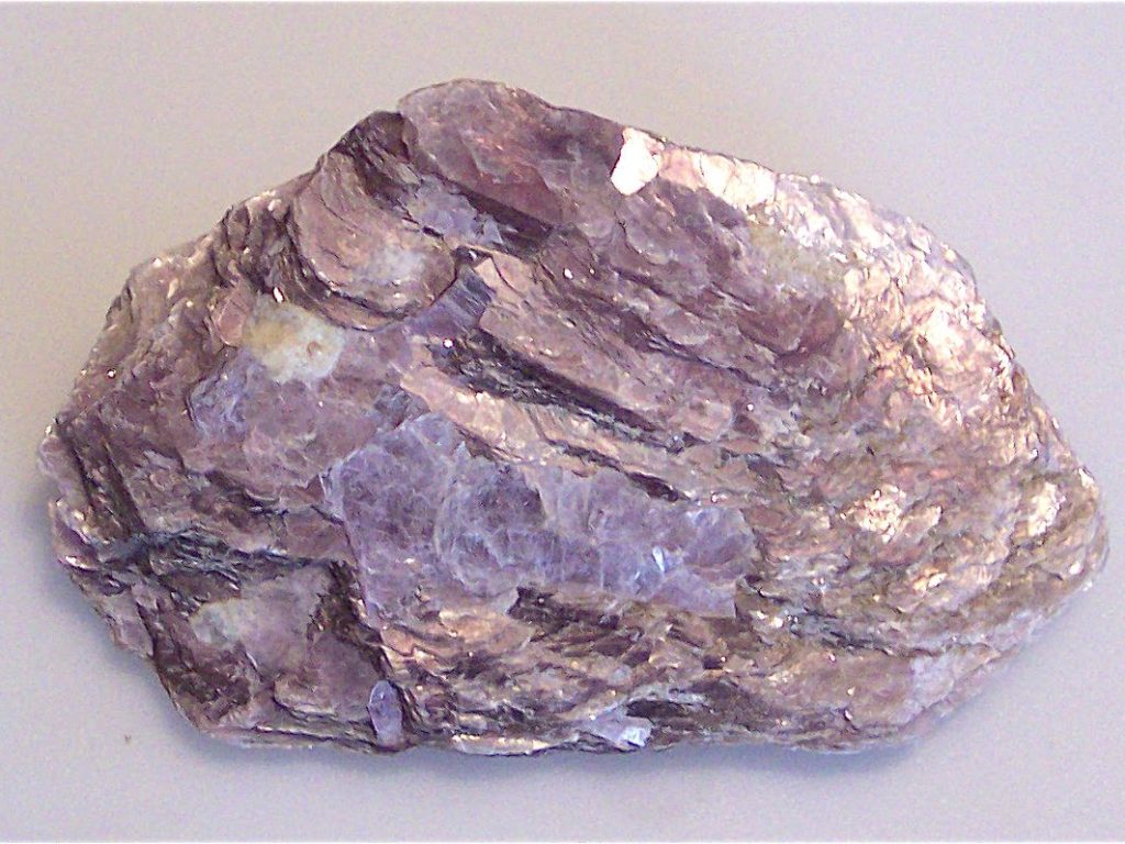 A large raw piece of lepidolite crystal, light pink colored.